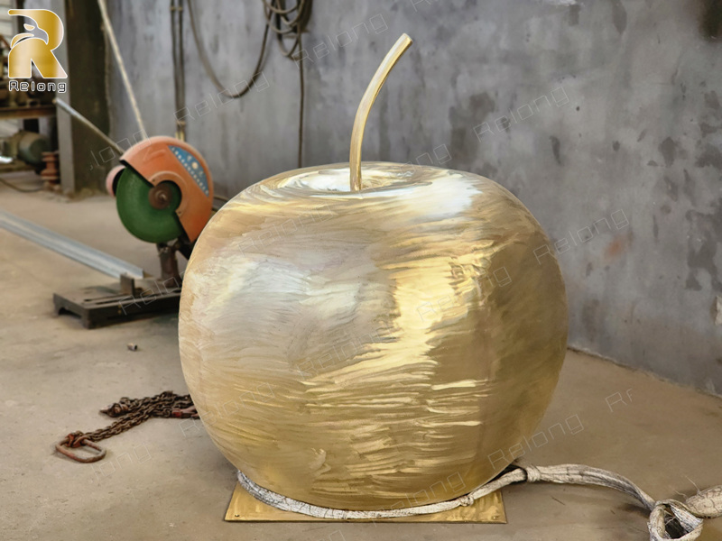 giant apple sculpture polishing