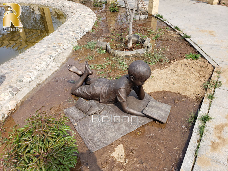 outdoor bronze boy reading book statue