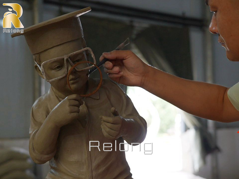 clay model of bronze reading boy statue