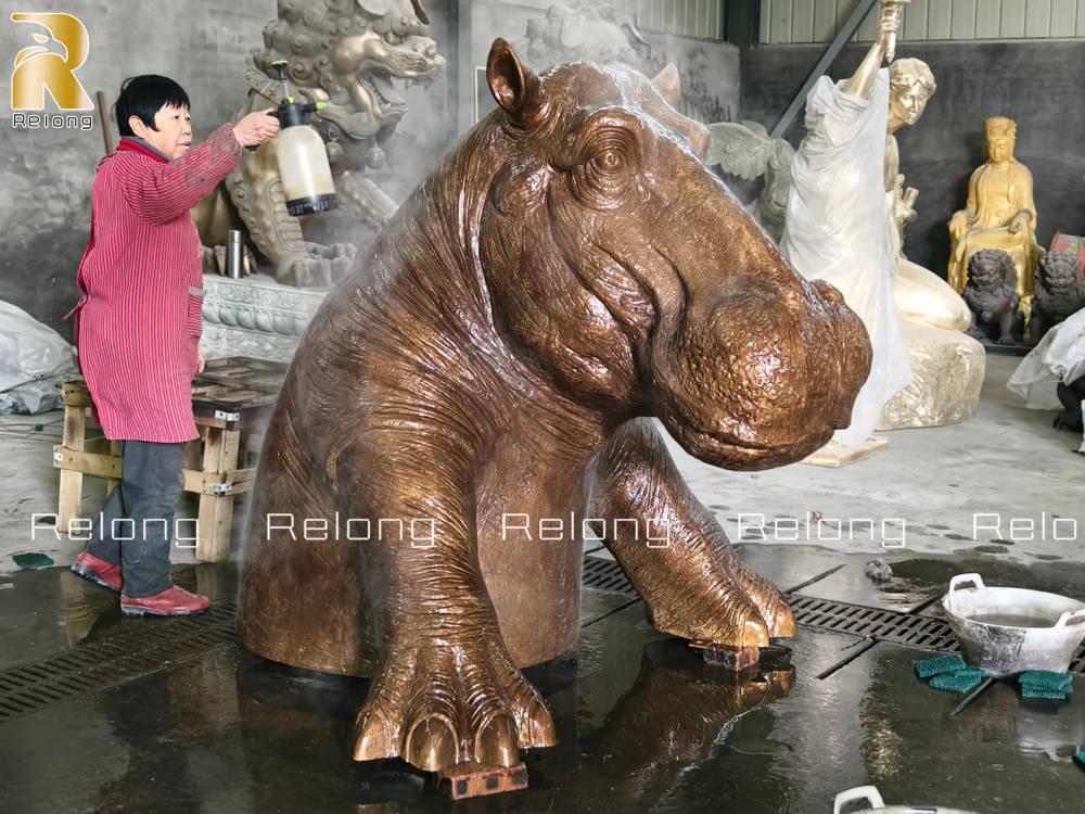 Relong artist coloring the  Hippopotamus statue