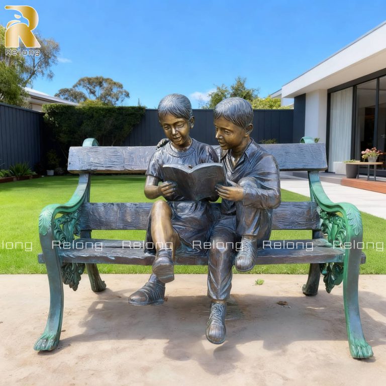life size bronze boy and girl sitting on a bench statue