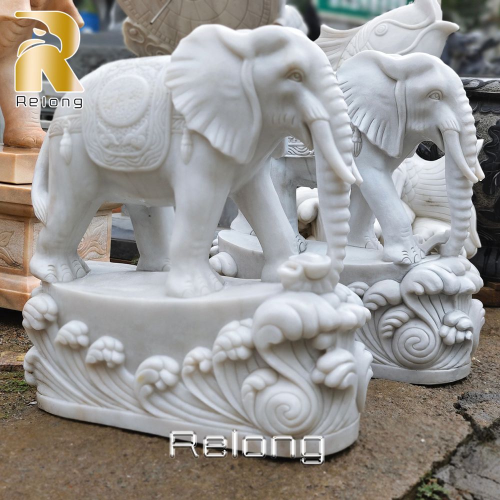 white marble elephant sculpture with waves base
